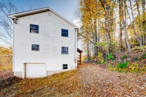a white house with a garage in the woods at Wardsboro Family Escape in Wardsboro