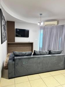 a living room with a couch and a flat screen tv at Sobrado Azul in Várzea Grande