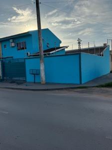 a blue building with a pole next to a street at Sobrado Azul in Várzea Grande