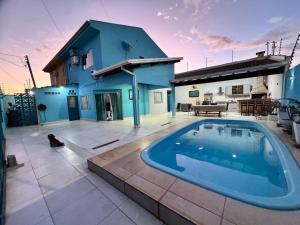 a large swimming pool in front of a house at Sobrado Azul in Várzea Grande