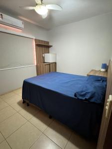a bedroom with a bed with a blue blanket at Sobrado Azul in Várzea Grande +17 photos