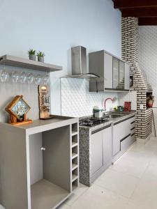 a kitchen with white cabinets and a counter top at Sobrado Azul in Várzea Grande
