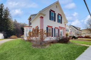 a white house with red shutters on a green yard at Pleasant Street 43 in Ludlow