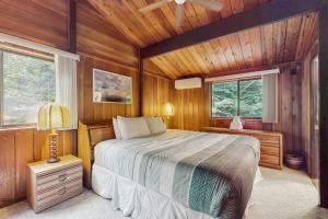 a bedroom with a bed in a room with wooden walls at Stowebury Retreat in Waterbury Center