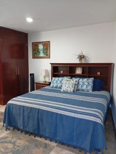 a bedroom with a large bed with a blue comforter at Cómodo departamento en Xochimilco in Mexico City