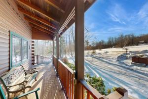 a porch with a bench and a snow covered yard at Chimney Hill Retreat in Wilmington