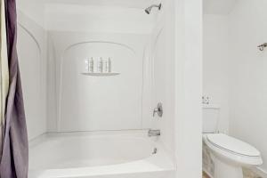 a white bathroom with a tub and a toilet at Equipe Sport 2E in Dover +29 photos