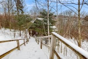 a wooden bridge in the snow with a house at Snowy Day Chalet in Killington