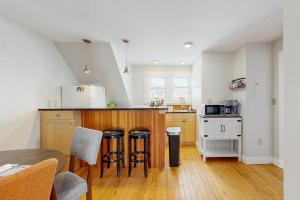 a kitchen with a counter and some stools in it at Stowe Mountain Road Retreat in Stowe +21 photos