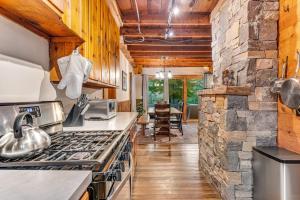 a kitchen with a stove and a stone wall at Lake Rescue Escape in Ludlow