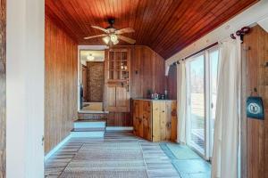 a kitchen with wooden walls and a ceiling fan at Vermont Mountain Farmhouse in Ludlow +87 photos