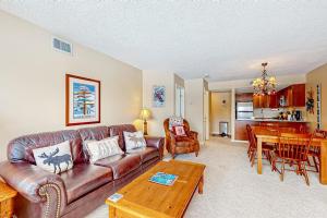 a living room with a leather couch and a table at Winterplace Condos H in Ludlow