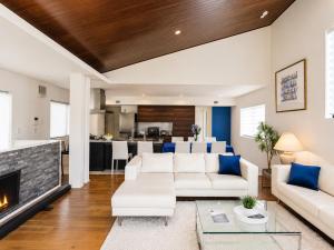 a living room with white furniture and a fireplace at Rayful Hayama in Hayama