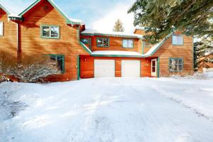 a house with two white garage doors in the snow at 515 Cache in Jackson
