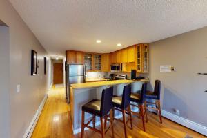 a kitchen with a counter with chairs and a counter top at Gore Creek Getaway in Vail