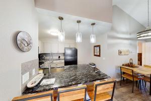 a kitchen with a table and a clock on the wall at Crazy Horse Condo in Edwards