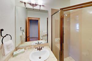 a bathroom with a sink and a shower and a mirror at Hilltop Palace in Fraser +58 photos