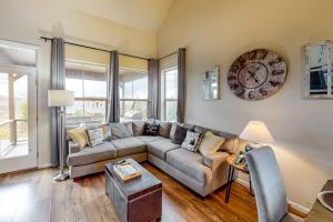 a living room with a couch and a clock on the wall at Summit Point Place in Granby