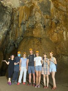 a group of people standing in front of a cave at Gold Plus hotel in Phong Nha +13 photos