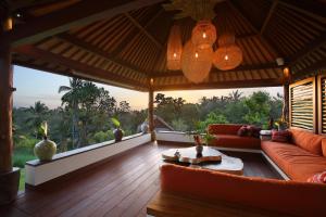 a living room with a couch and a table at Villa Palem in Tabanan