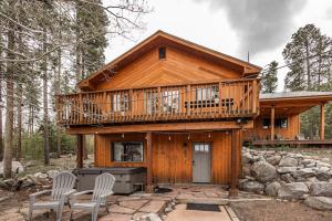 a large wooden house with a balcony and two chairs at Mountain Calling in Grand Lake