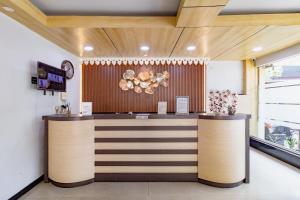 a restaurant with a counter with flowers on it at RedDoorz Plus at Suba Hotel Tanjung Duren in Jakarta