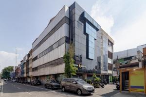 a building on a city street with cars parked at RedDoorz Plus at Suba Hotel Tanjung Duren in Jakarta