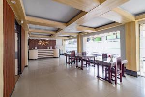 a dining room with wooden ceilings and tables and chairs at RedDoorz Plus at Suba Hotel Tanjung Duren in Jakarta