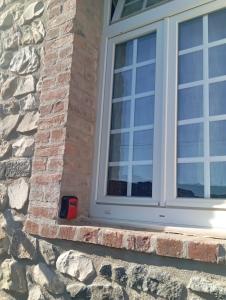 a window on a brick wall with a red candle at Maisonnette en pierre in Saint-Victor-de-Malcap