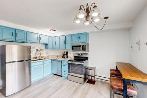 a kitchen with blue cabinets and a stainless steel refrigerator at Mountain Delight in Crested Butte