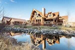 a log home with its reflection in the water at South Fork Sanctuary in South Fork