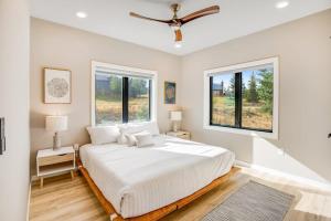 a bedroom with a large bed and two windows at Enchanted Alps - Whole Home Permit 301,470 in Crested Butte