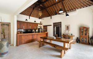 a large kitchen with a wooden table and a counter at Villa Nesanur - Comfortable & Spacious Beachside Sanur in Sanur