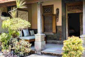 a porch of a house with a bed on it at Villa Nesanur - Comfortable & Spacious Beachside Sanur in Sanur