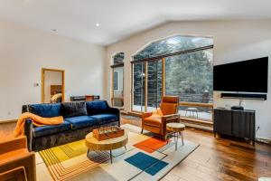 a living room with a blue couch and a tv at Snowy Peak Sanctuary in Vail