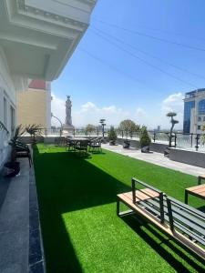 a park with benches and tables on the grass at Ammar Hotel in Dushanbe