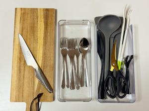 a container filled with utensils next to a cutting board at Goryokaku rental house SAKURA in Hakodate