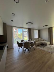 a living room with a couch and a table and chairs at Karaliauciaus Apartment in Vilnius