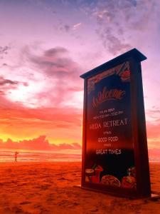 a sign on the beach with the sunset in the background at Heda Retreat in Aluthgama