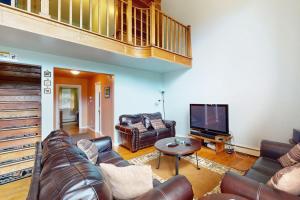 a living room with a couch and a tv at Timberline Chalet in Breckenridge