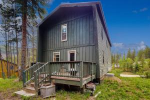 a green house with a porch on a field at Timberline Chalet in Breckenridge