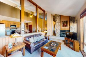 a living room with a leather couch and a tv at Mountainside 037 in Granby
