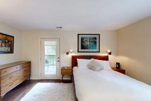 a bedroom with a large white bed and a dresser at River Pines Retreat in Edwards