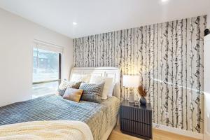 a bedroom with a bed and a large window at SunSong Escape in Fraser