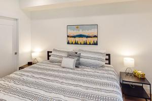 a white bedroom with a large bed with two lamps at Blue River Dream in Silverthorne