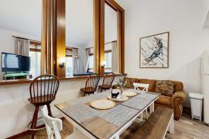 a living room with a table and chairs and a couch at Mountainside 049 in Granby