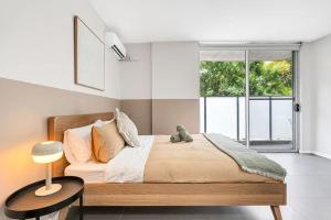 a bedroom with a bed with a table and a window at 4B Relaxing Abnb Studio With Balcony, Near Marketplace And Train in Bankstown
