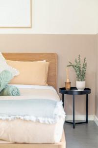 a bedroom with a bed and a table with a plant at 4B Relaxing Abnb Studio With Balcony, Near Marketplace And Train in Bankstown