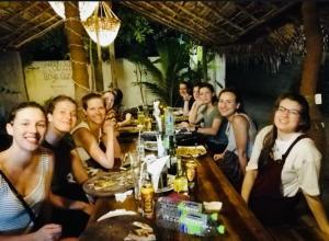 a group of people sitting at a table in a restaurant at Cili Hotel & Pizza Restaurant in Arugam Bay