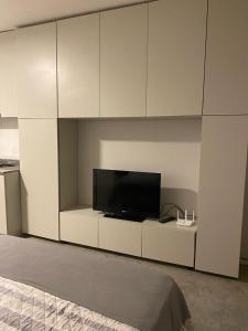 a living room with a tv and white cabinets at Monoambiente céntrico in Gualeguaychú